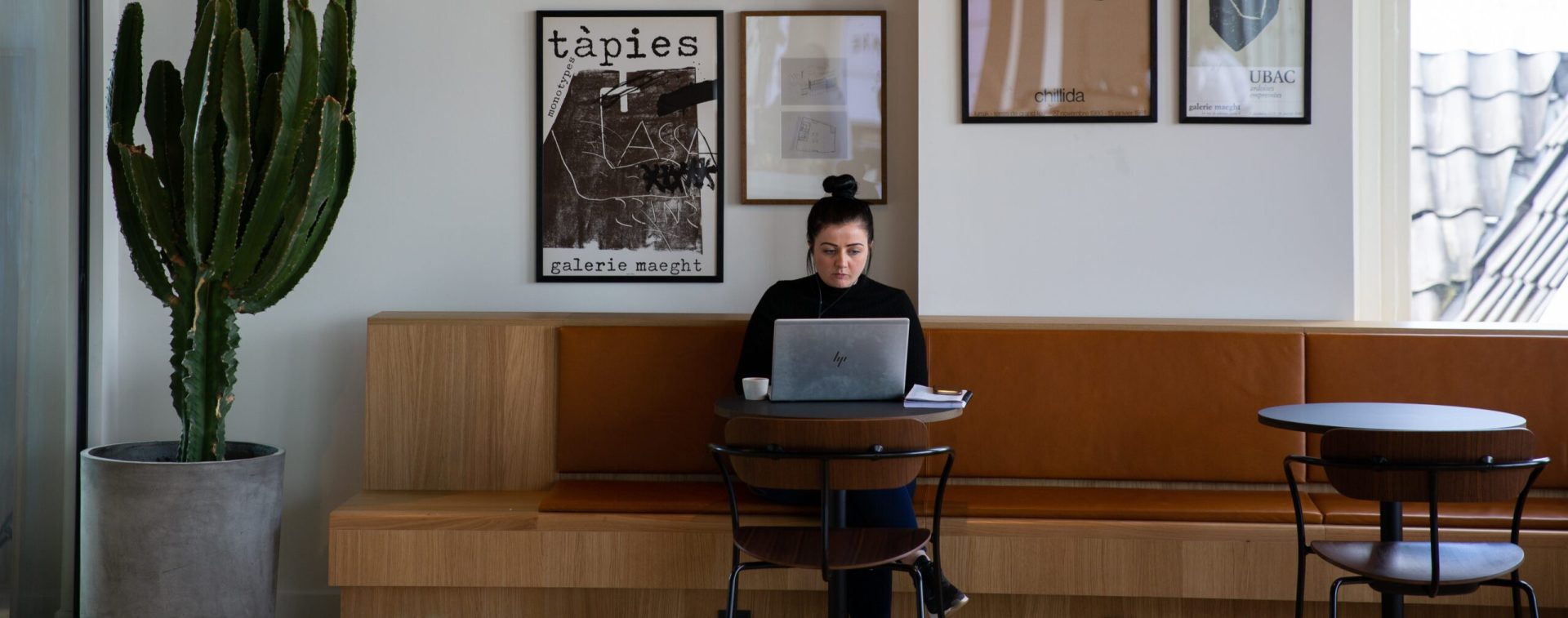 ragazza seduta ad un bar che lavora al computer