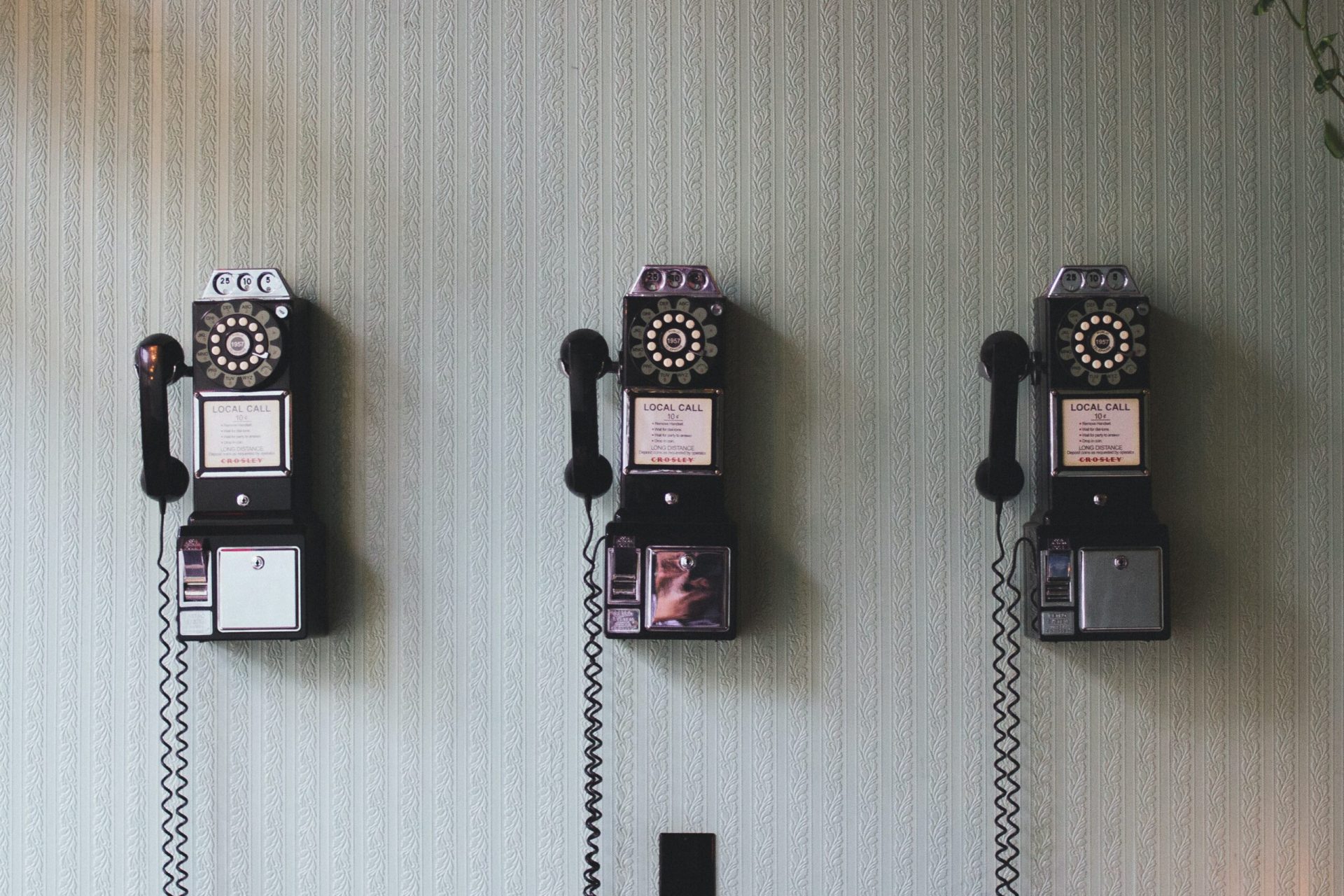 tre telefoni vintage appesi al muro